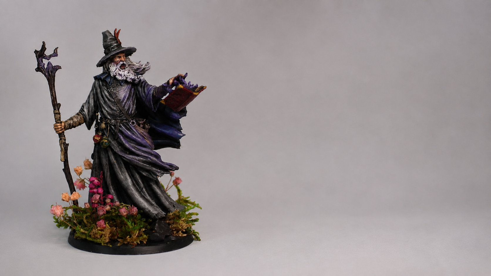 A painted wizard miniature on a graded studio backdrop